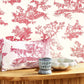 Pink toile patterned wallpaper with decorative elements on a white background.