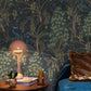 Room interior with peacock wallpaper, table lamp, and decorative items.