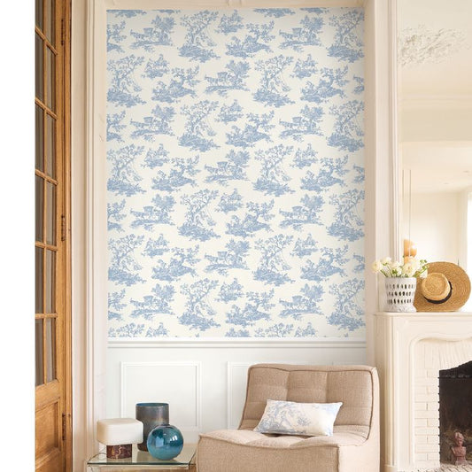 Living room with beige armchair, decorative items, and blue floral wallpaper.