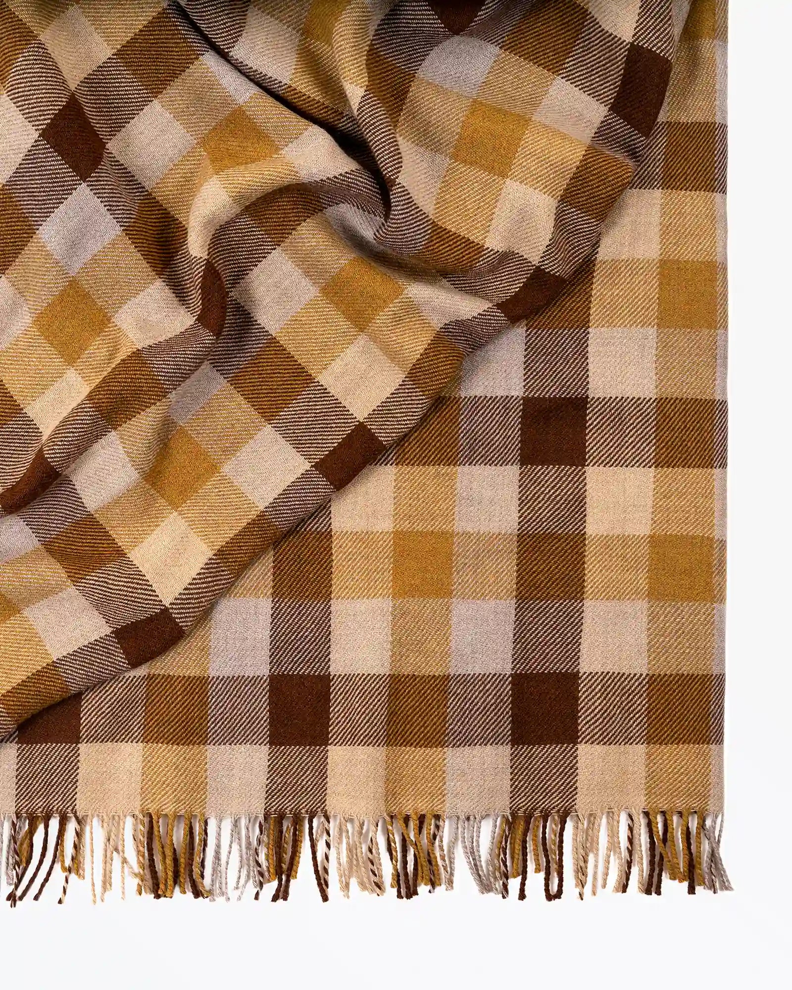 Plaid blanket with brown, beige, and white pattern on a white background