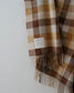 Plaid scarf with fringes on a white background