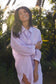 Woman wearing a lilac linen shirt in a tropical setting