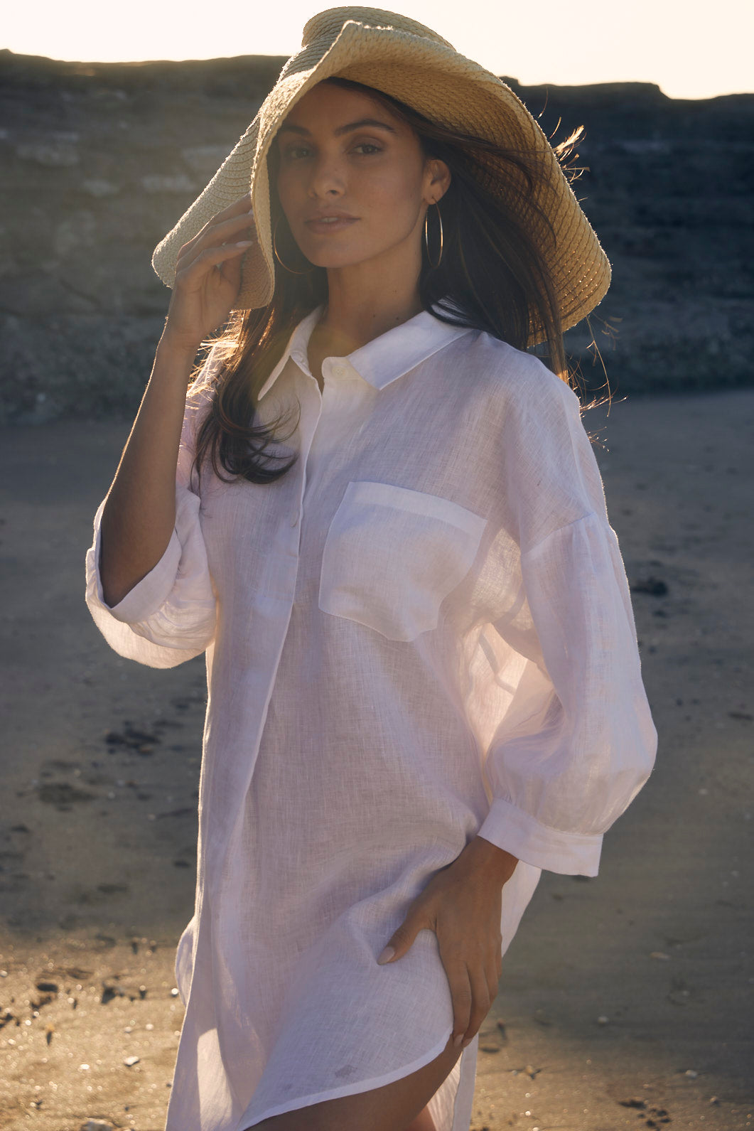 Woman wearing a white shirt and straw hat on a beach