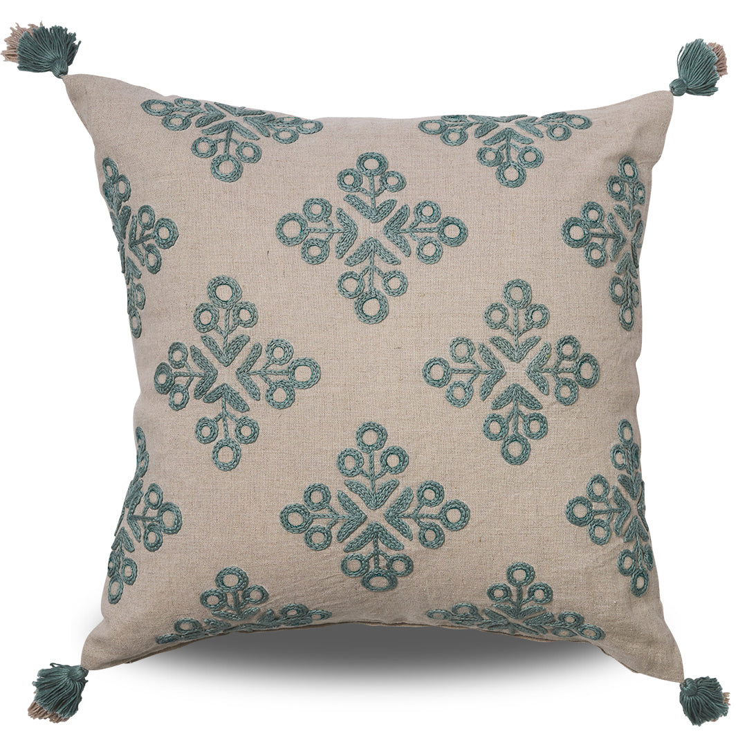 Natural coloured linen cushion with blue embroidered motifs and tassels on each corner
