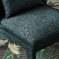 Patterned fabric on a piece of furniture with a floral rug in the background