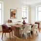 Dining room with a wooden table and chairs, featuring a vase and abstract art on the wall.