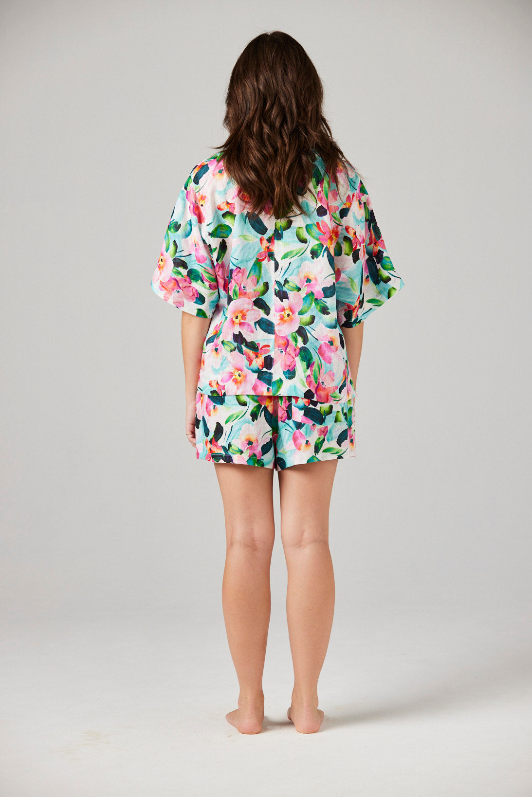 Person wearing a floral pajama set on a plain background