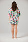 Person wearing a floral pajama set on a plain background