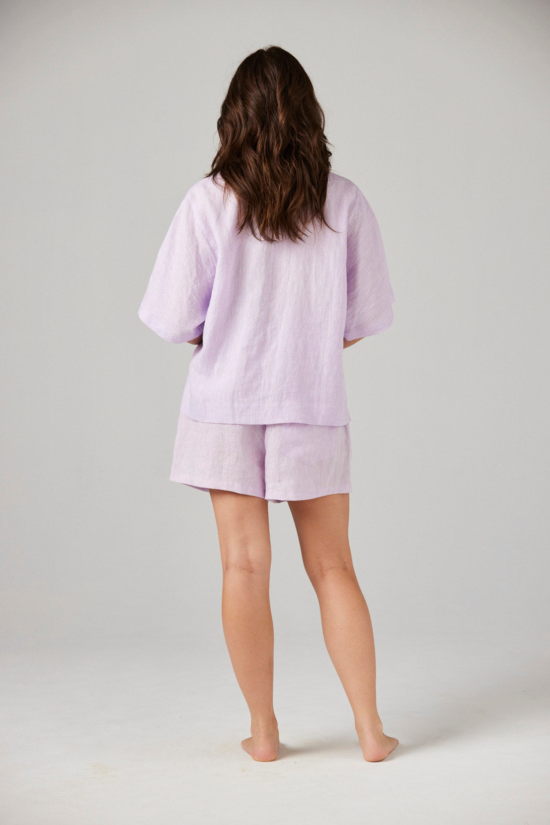Person wearing a light purple pajama set on a plain background