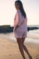 Woman in a striped outfit walking on a beach