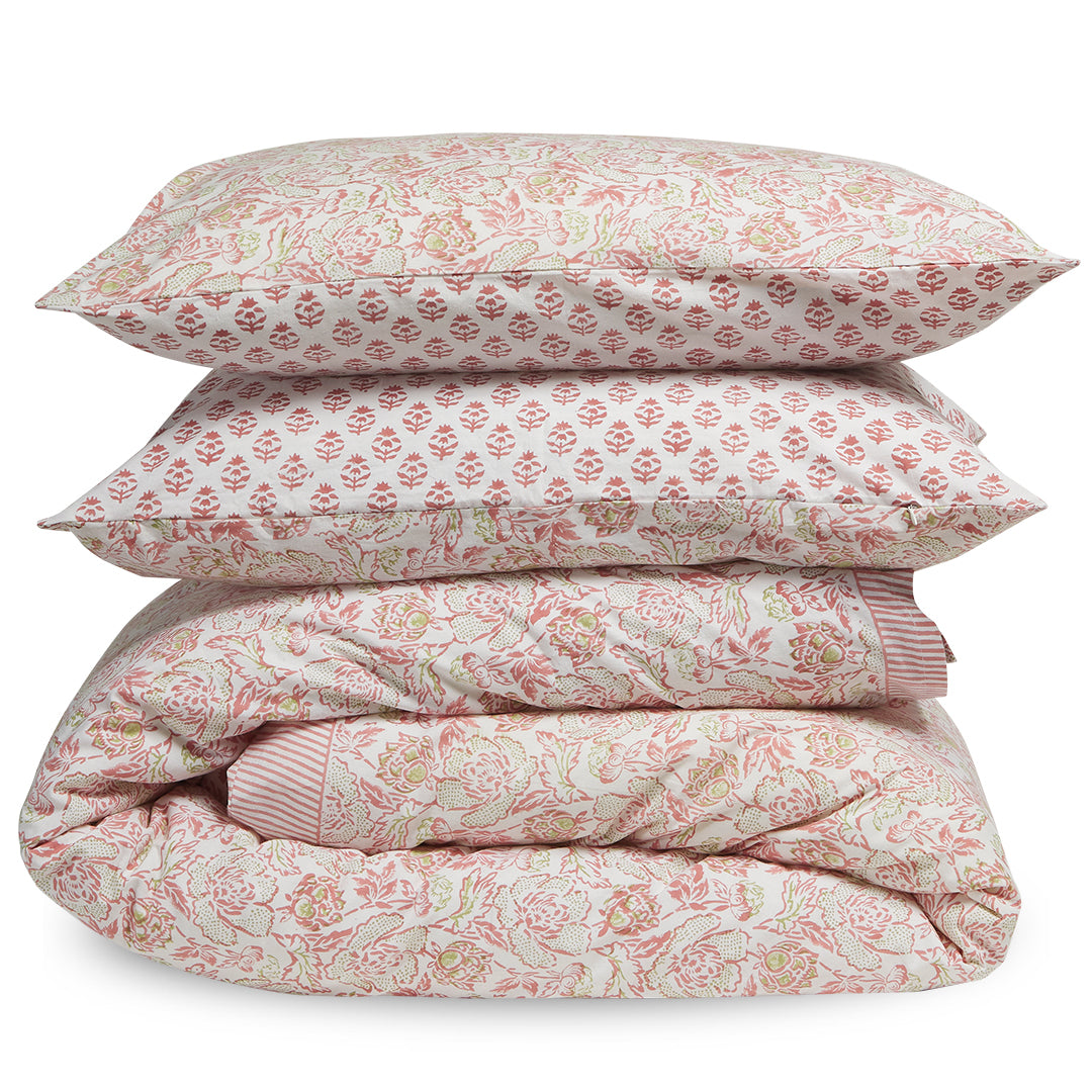 Floral patterned bedding set with a comforter and two pillows on a white background