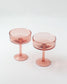 Two pink cocktail glasses on a white background