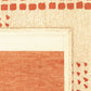 Close-up of a woven rug corner showing a cream border with orange-red geometric patterns and a matching orange-red central panel on a beige background.