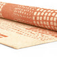 Rolled up patterned rugs with geometric designs on a white background