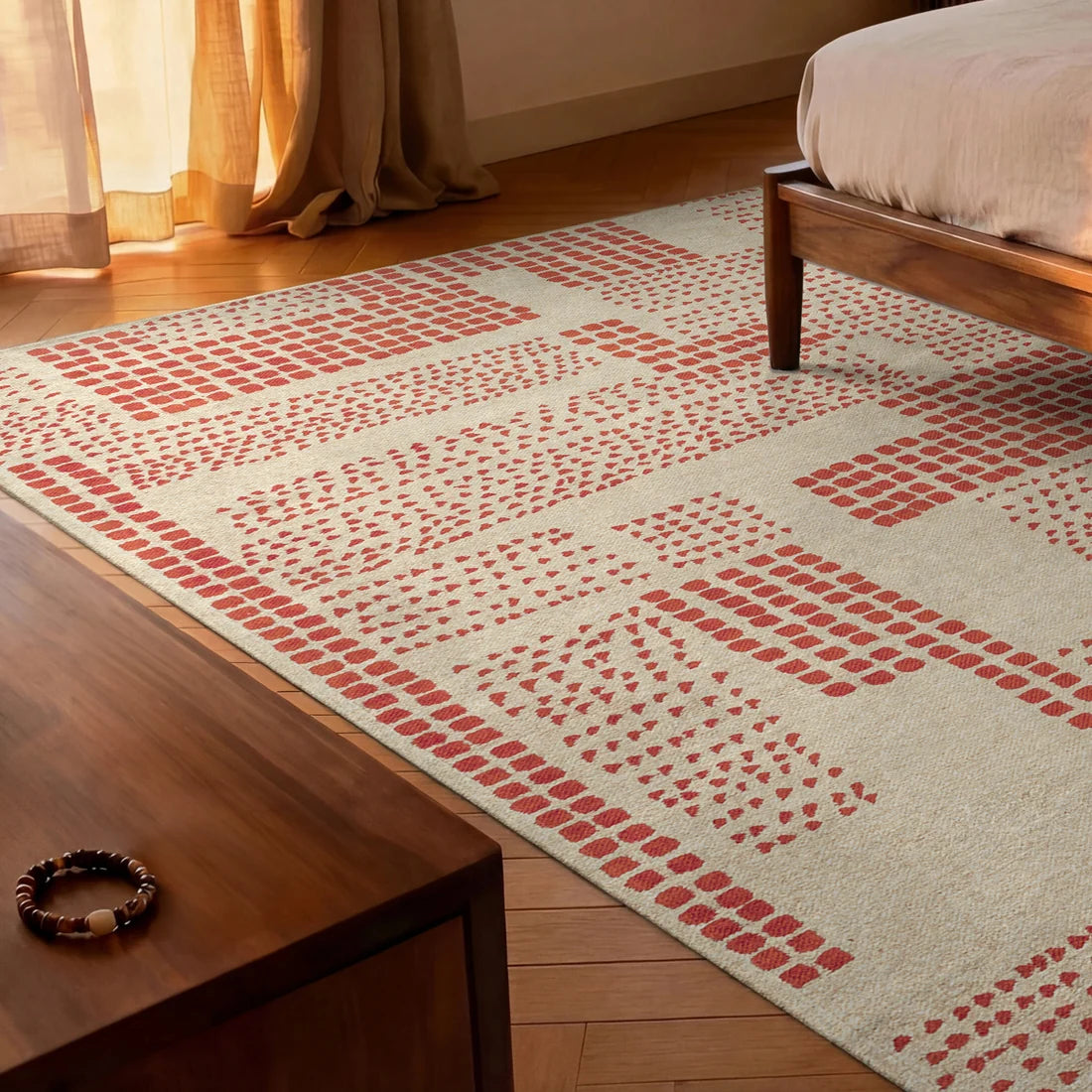 Patterned rug on a wooden floor with a bed and curtain in the background