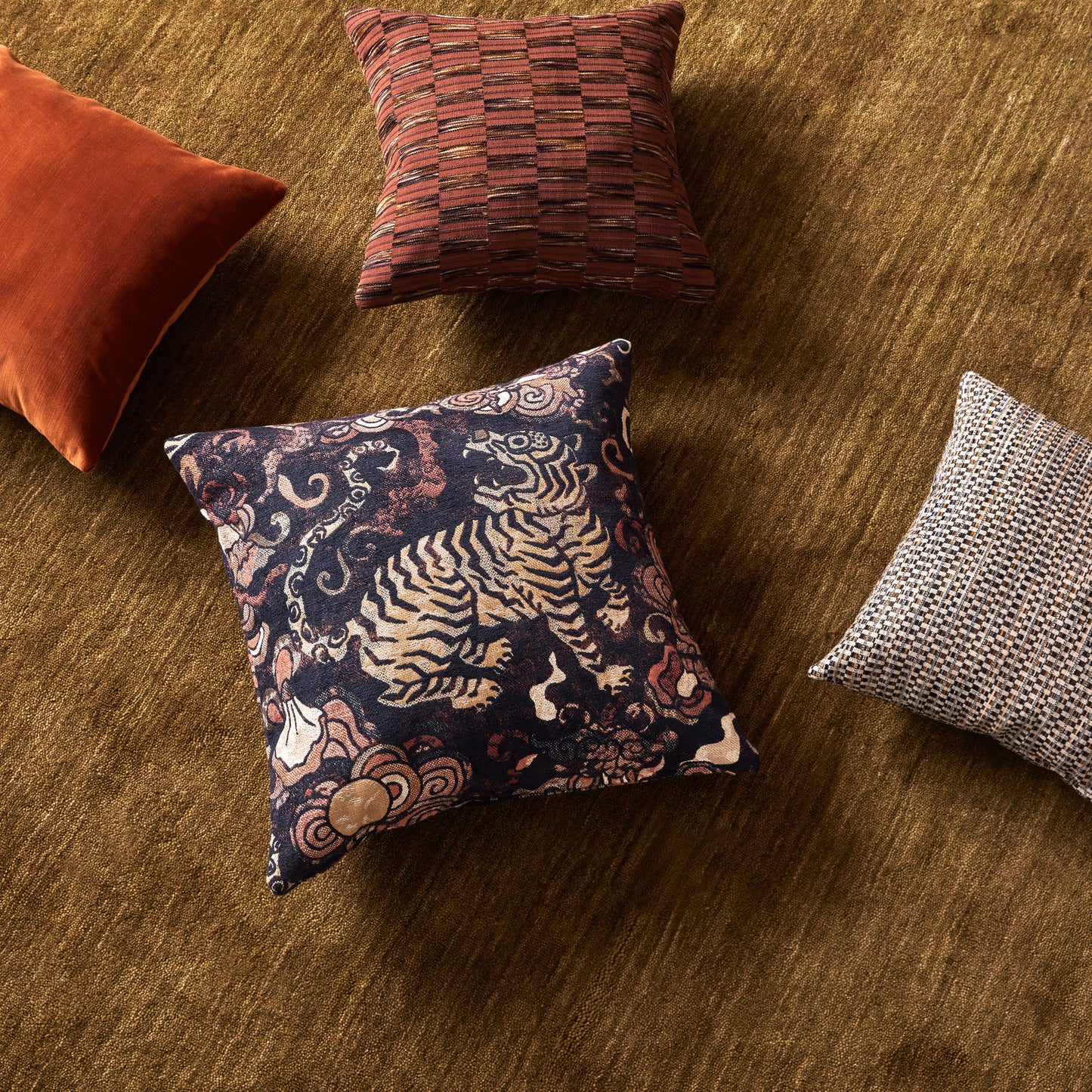 Four patterned cushions on a textured surface