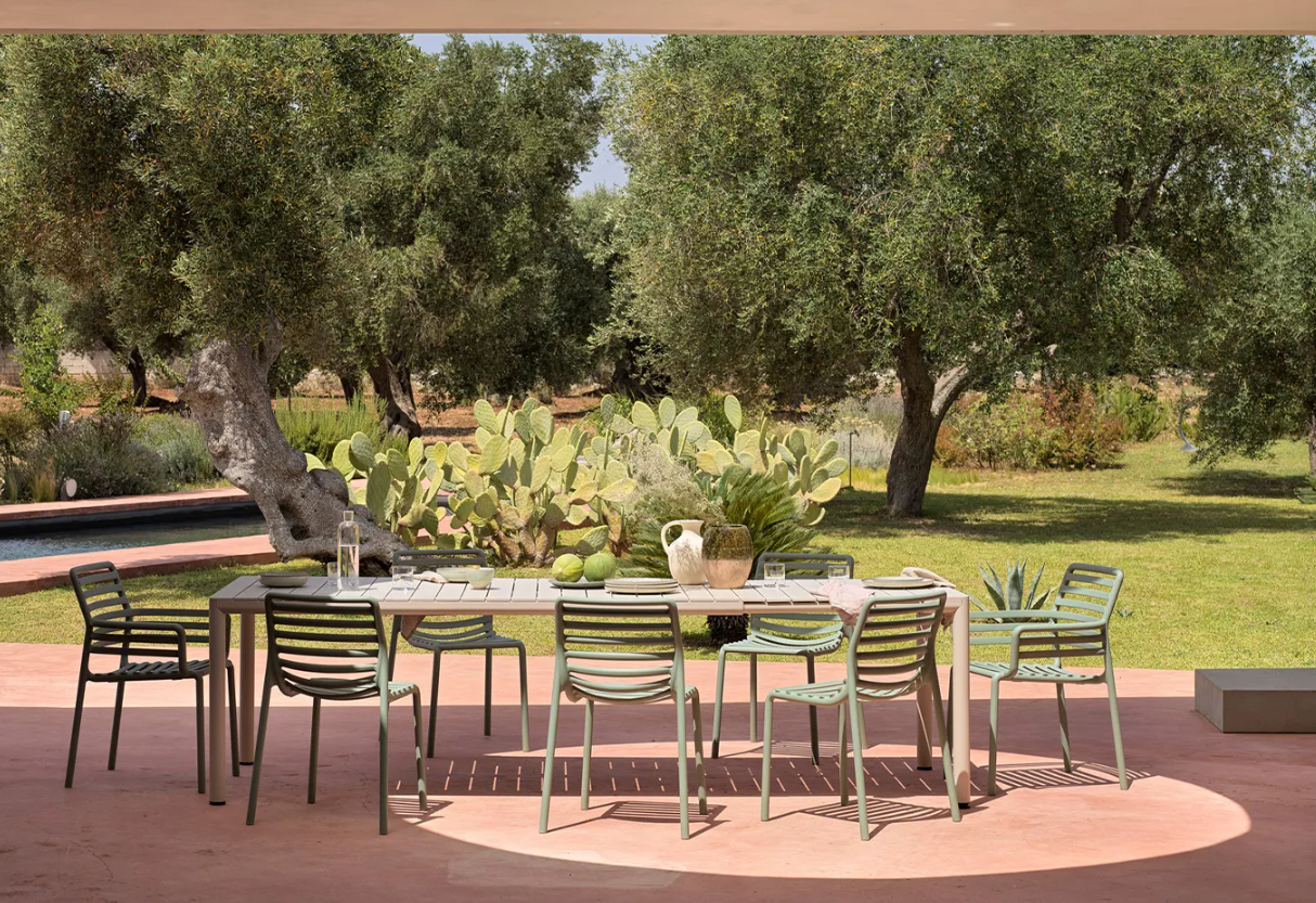 Outdoor dining setup with table and chairs in a garden setting