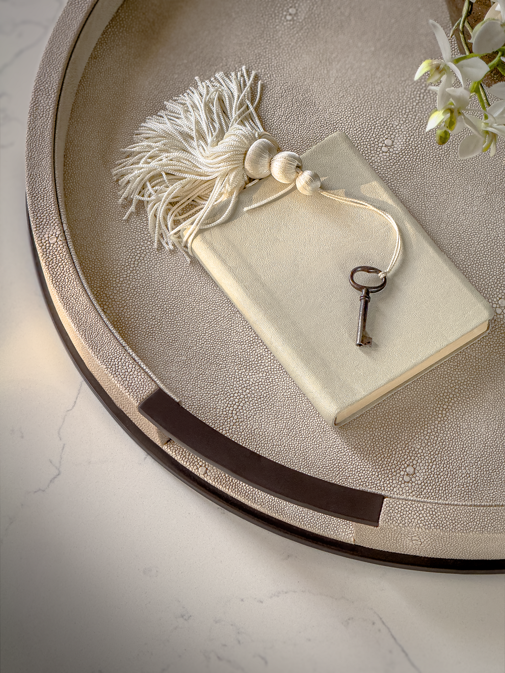 Decorative key and tassel on a stone surface with a neutral background