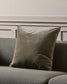 Thyme cushion on a gray sofa against a neutral wall