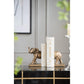 Bronze elephant figurines on books with a neutral background