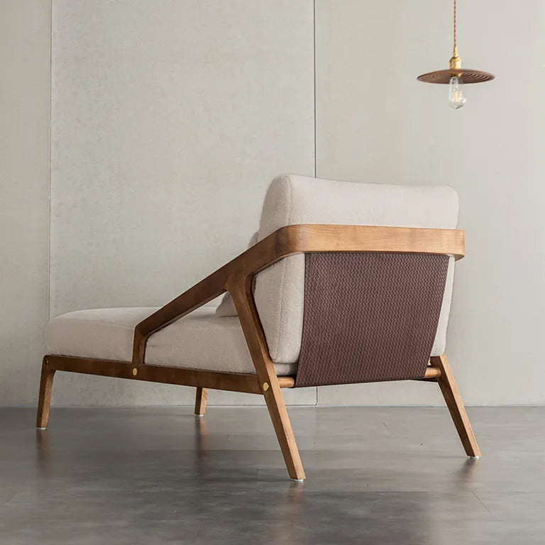 Modern lounge chair with wooden frame and fabric seat and backrest in a minimalistic room.