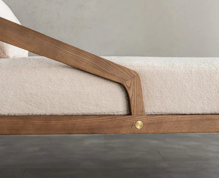 Close-up of a wooden bed frame with beige mattress on a neutral background