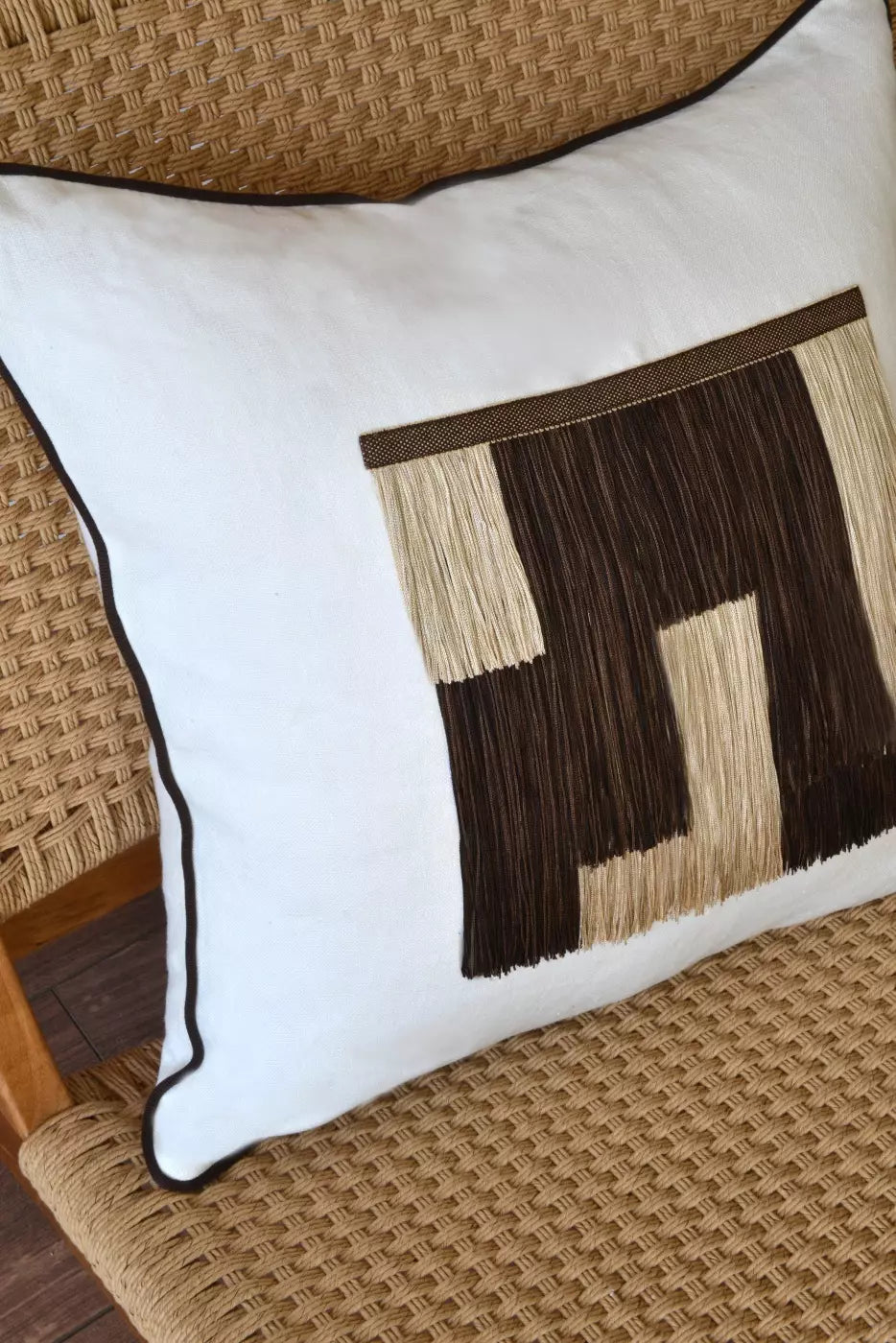 Decorative pillow with geometric pattern on a woven chair