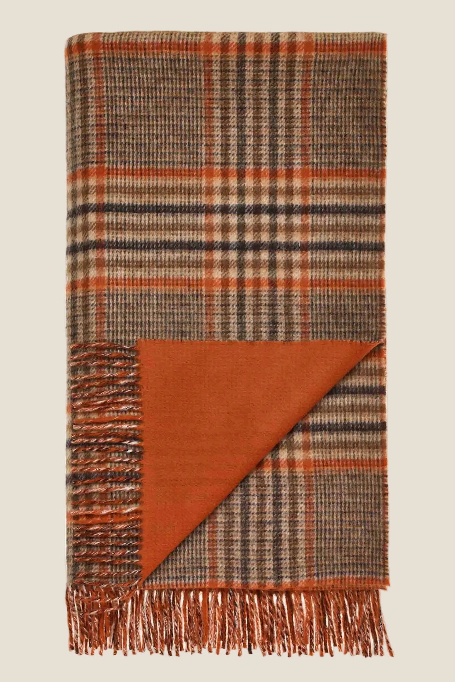 Plaid blanket with fringes on a beige background