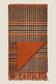 Plaid blanket with fringes on a beige background