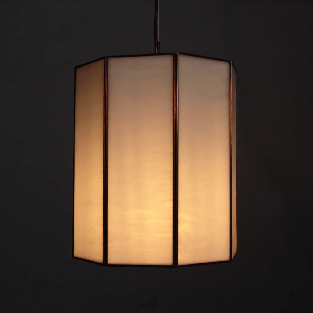 Hexagonal lamp with a warm glow on a black background