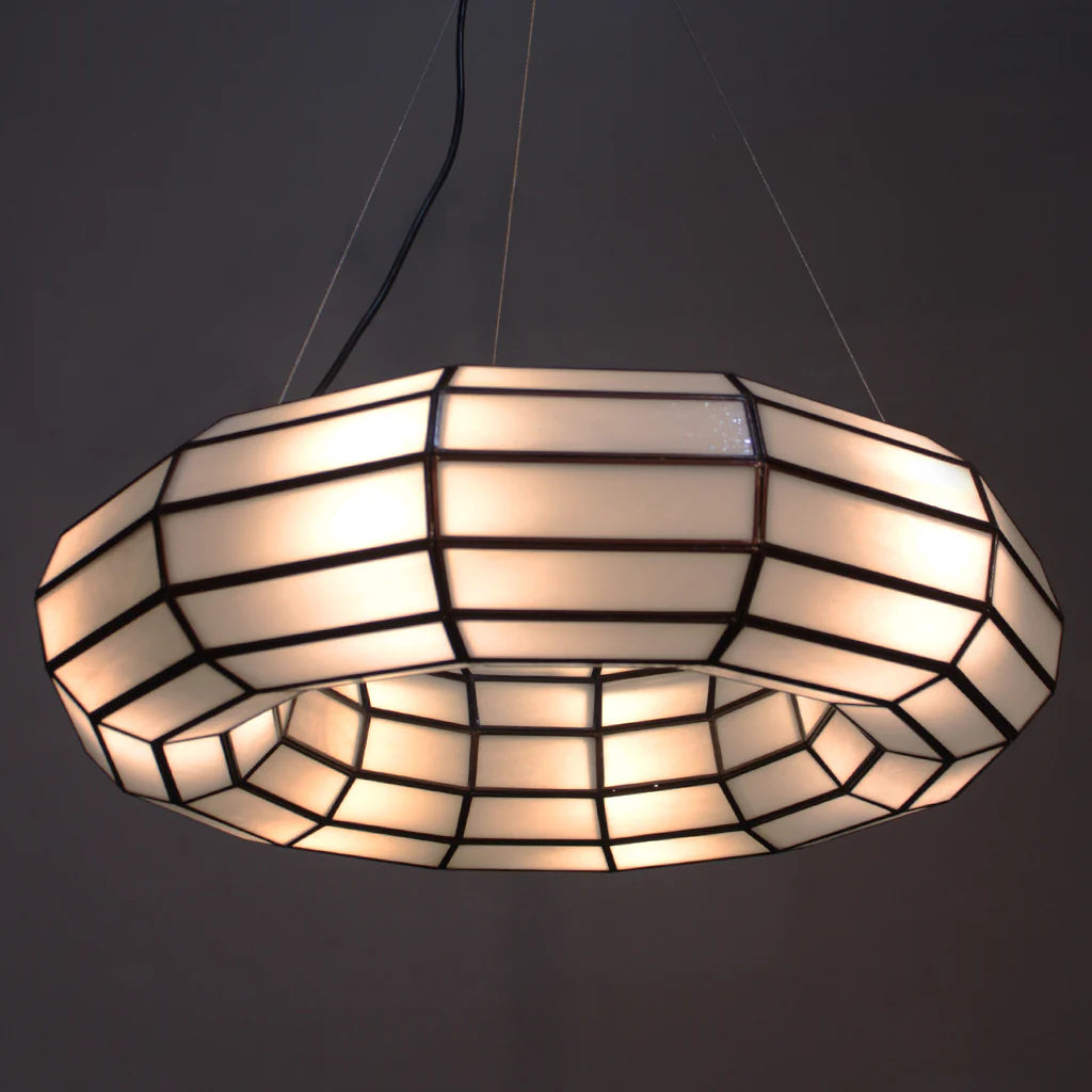 Stained glass pendant light with a geometric pattern on a dark background