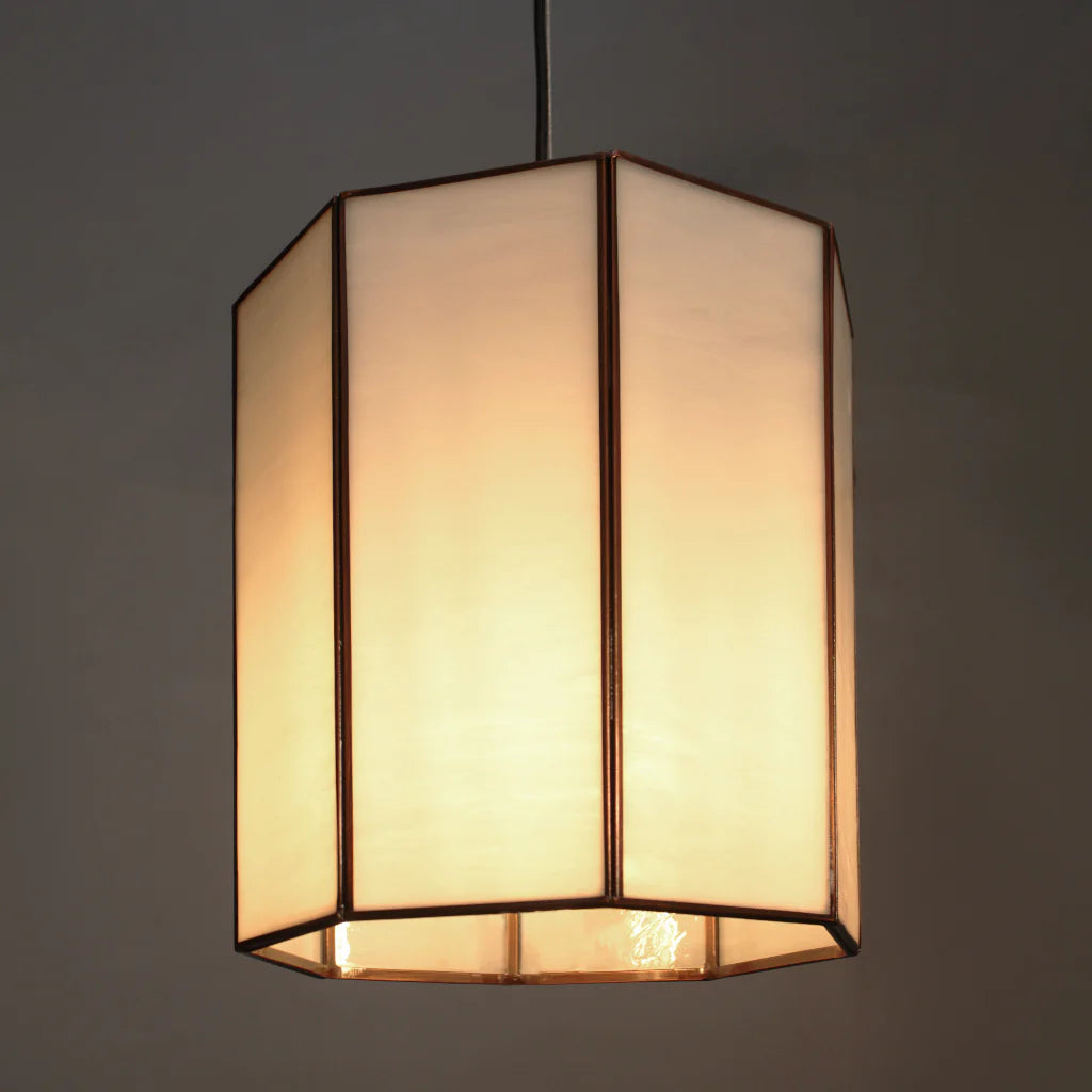Hexagonal pendant light with a beige lampshade on a dark background