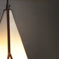 Close-up of a pendant light with a gradient from white to warm yellow against a dark background