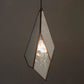 Geometric pendant light with a white glass shade and copper frame on a dark background