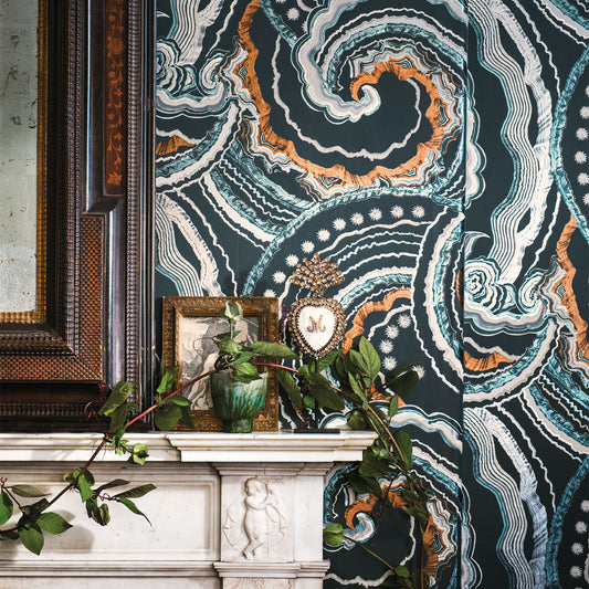 Decorative wallpaper with abstract pattern in a room with a fireplace and framed picture.
