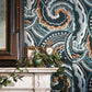 Decorative wallpaper with abstract pattern in a room with a fireplace and framed picture.