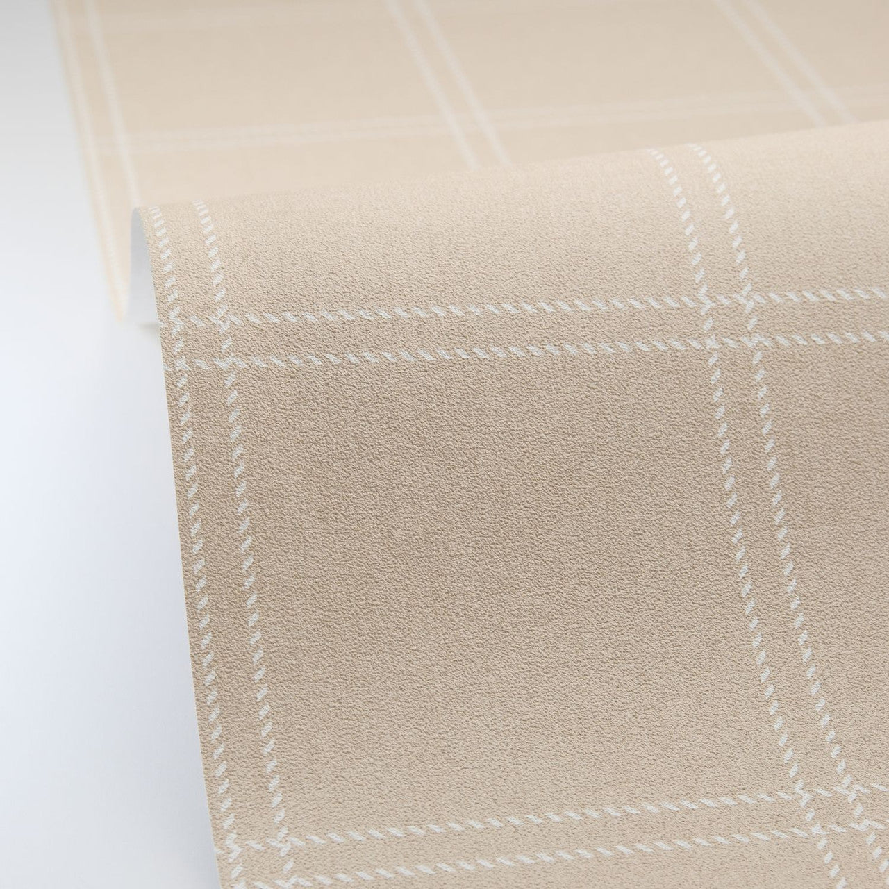Close-up of beige fabric with white windowpane pattern on a light gray background