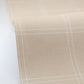 Close-up of beige fabric with white windowpane pattern on a light gray background