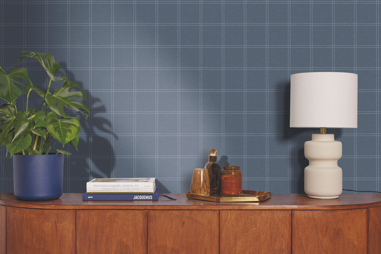 Wooden sideboard with decorative items against a blue grid-patterned wall