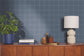 Wooden sideboard with decorative items against a blue grid-patterned wall