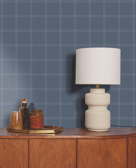 White lamp on a wooden surface with a blue checkered wall background