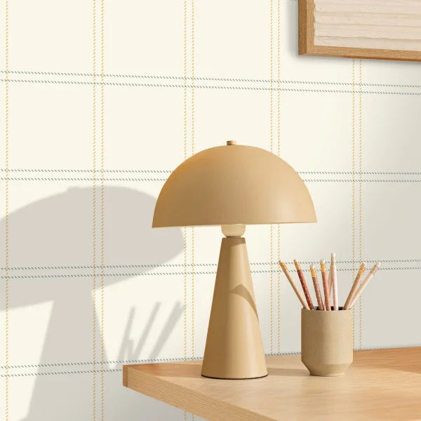 Beige table lamp on a wooden surface with a light-colored wall background