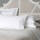 White pillows on a bed with a textured headboard