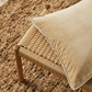 Francesca cushion on a woven stool with a roughly textured carpet