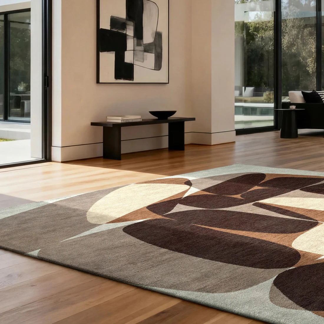 abstract rug with organic shapes in brown, beige and cream on a wooden floor with black modern furniture and art