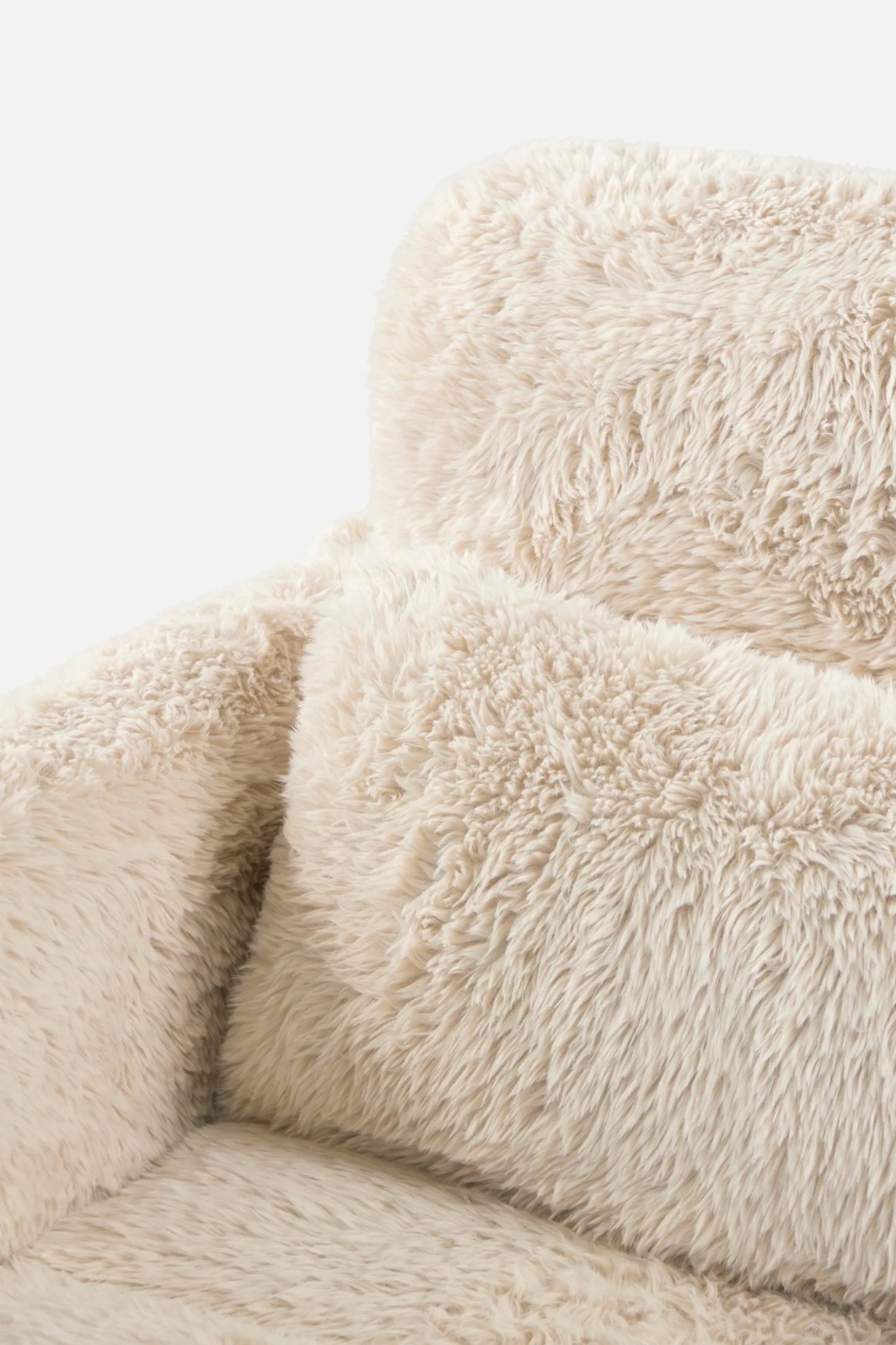 Close-up of a fluffy beige faux sheepskin chair on a white background