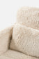 Close-up of a fluffy beige faux sheepskin chair on a white background