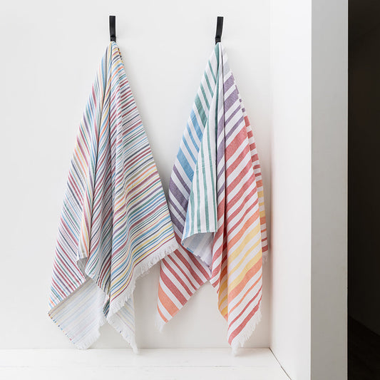Colorful striped towels hanging on a rack against a white wall.