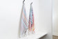 Two striped towels hanging on a rack against a white wall.