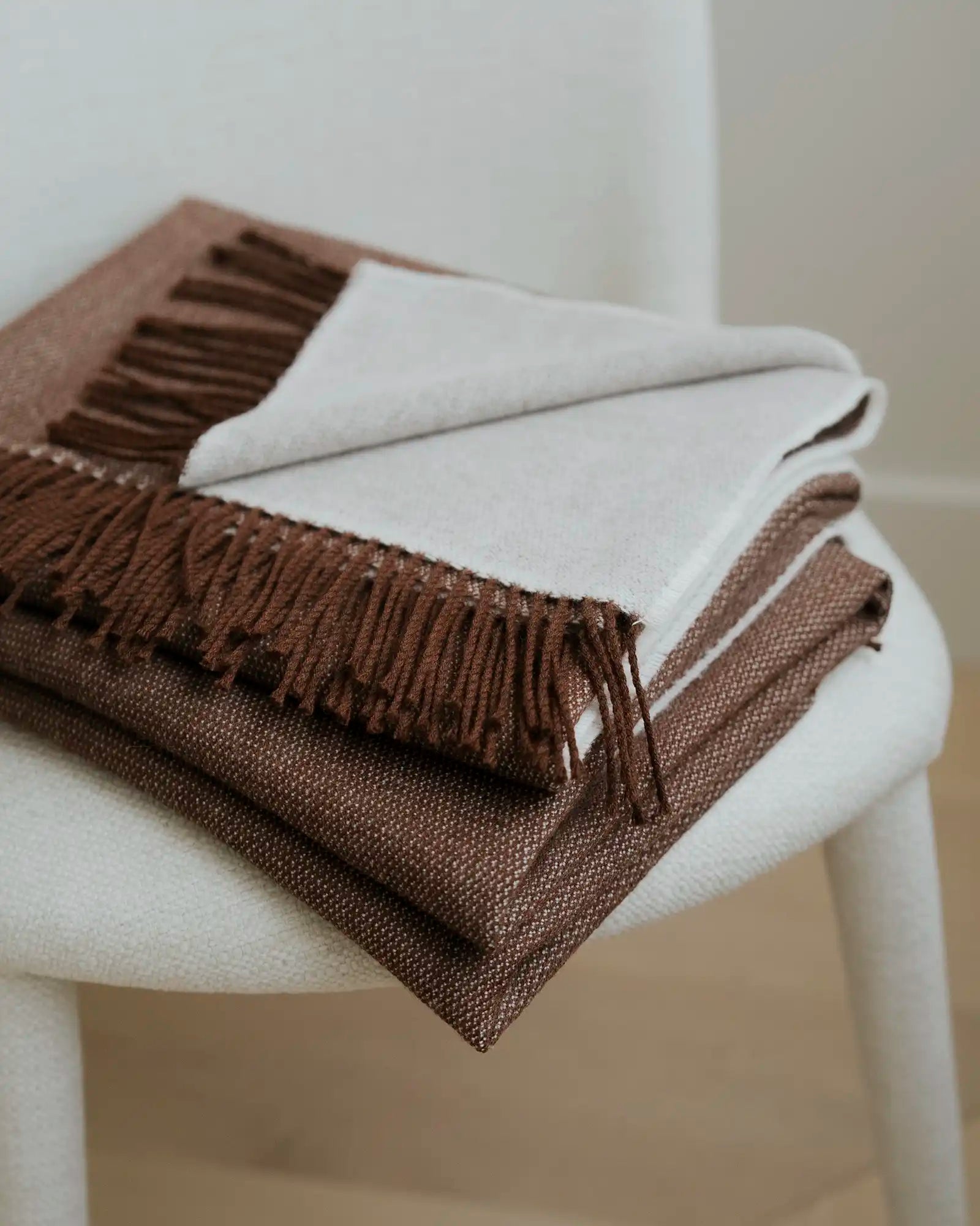 Brown and beige plaid blanket on a white chair